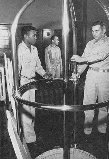 Uniformed men standing near metal cage